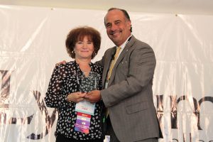 Barbara Dubel receiving an award from Dr. Cordero