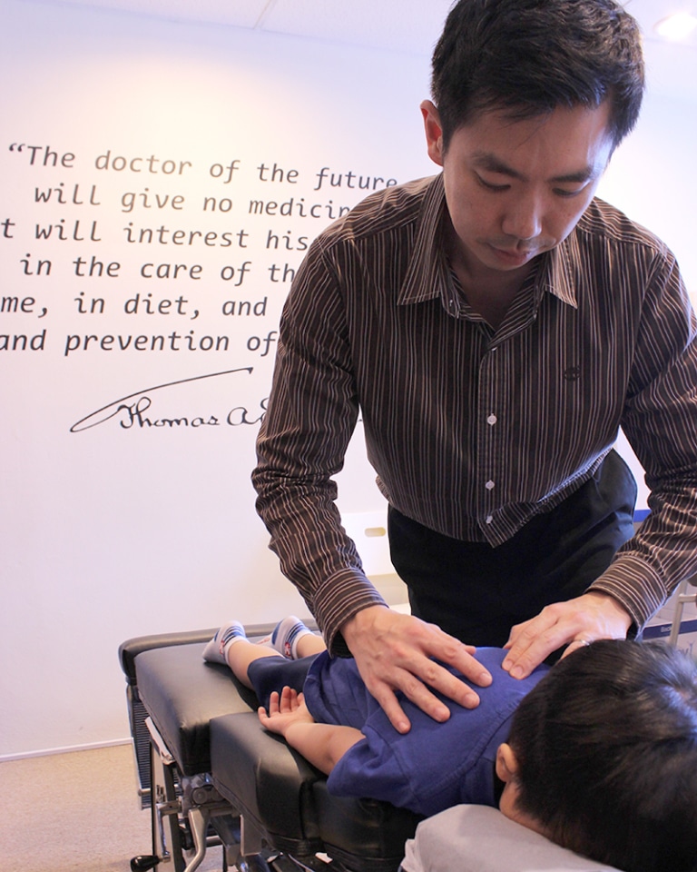 Image of chiropractor adjusting child.