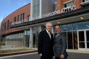 Dr. Thom Gelardi, Sherman College founder, and Dr. Edwin Cordero, Sherman College president stand in front of the newly completed Gelardi Student Center at Sherman College of Chiropractic. 