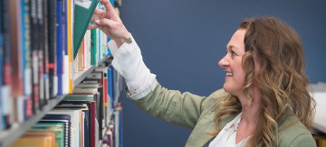 Student grabbing a book