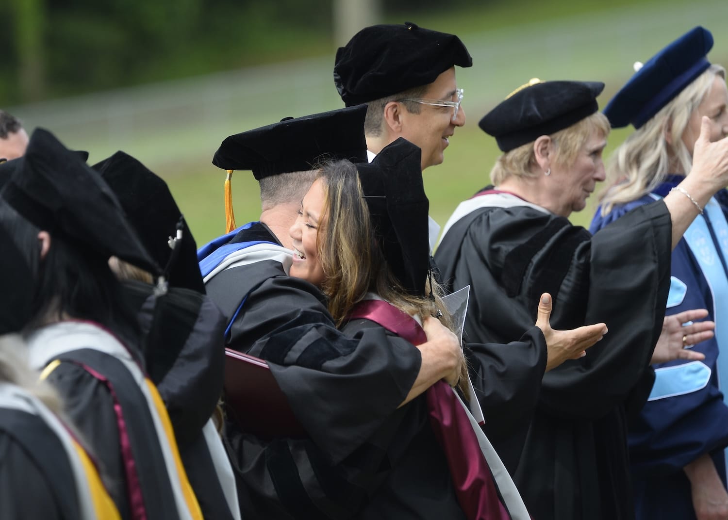 sherman faculty hugging new graduate at ceremony