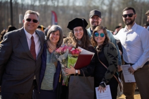 Sherman College graduate celebrates with family outside after graduation ceremony