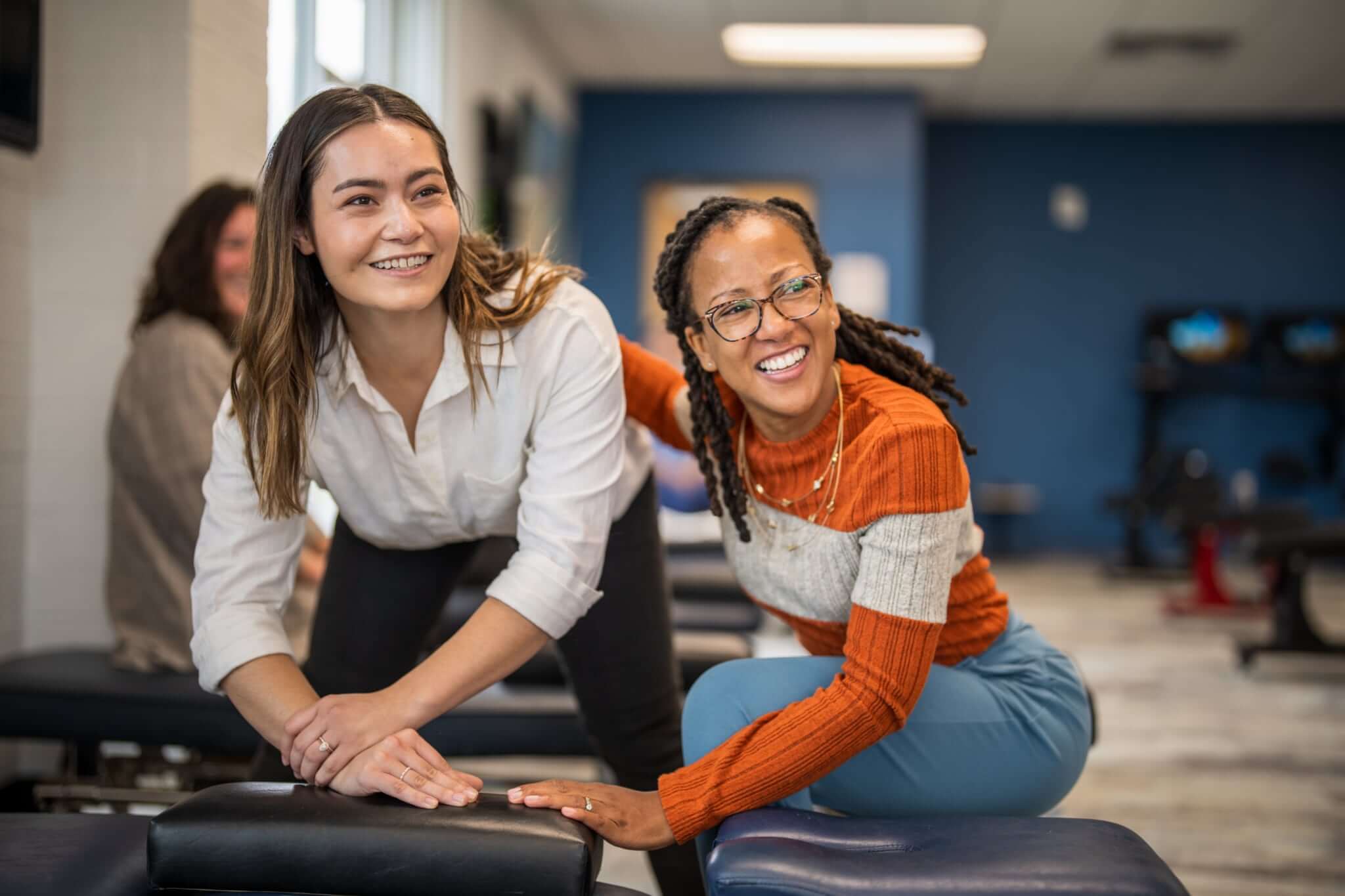 Chiropractor mentoring associate in a clinical setting, demonstrating hands-on technique and mentorship during an associate training session.