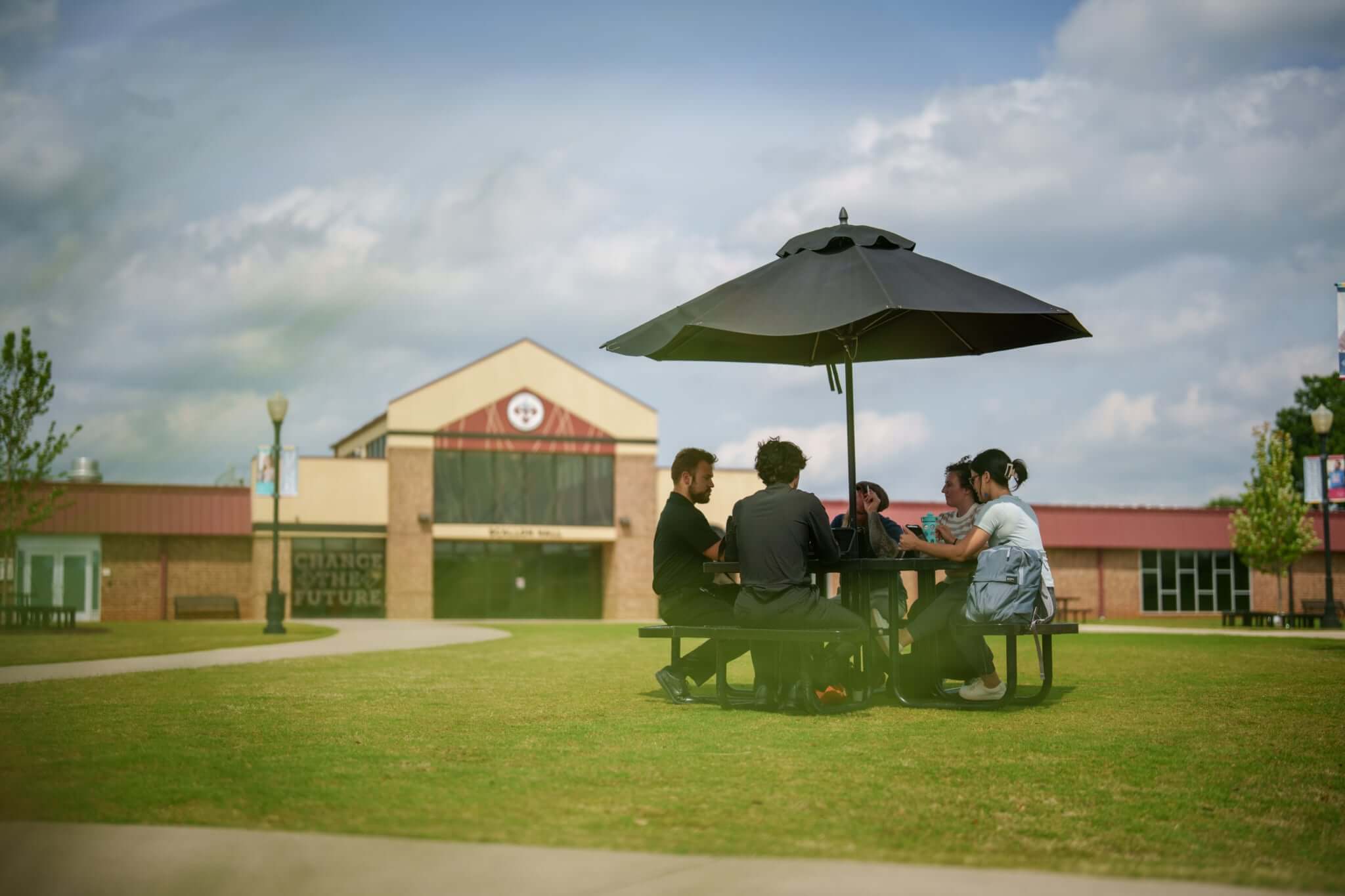 Group of Sherman College students sitting together at a table outside on campus